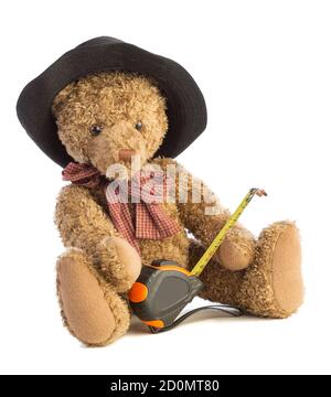 Teddy bear with a construction meter and a black hat on white background Stock Photo