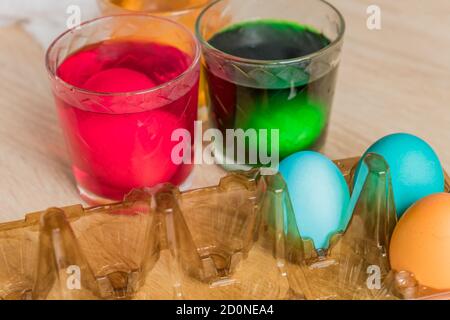 Glass with orange, red and green paint for Easter eggs. Easter Egg decorating. Stock Photo