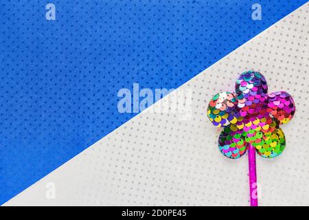 flower made of sequins on double white and blue star background background. Minimal flat lay, copy space Stock Photo