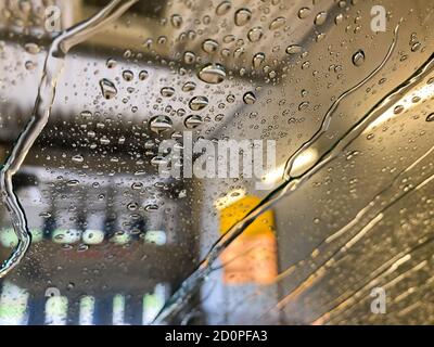 View from inside on windshield with water drops and streaks in automatic car wash facility Stock Photo