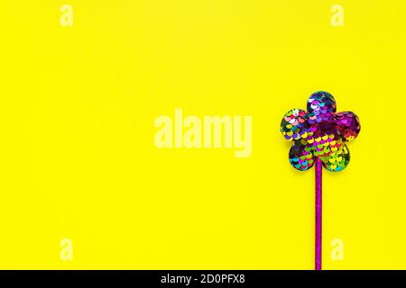 flower mae of sequins on bright yellow background. Minimal flat lay, copy space Stock Photo