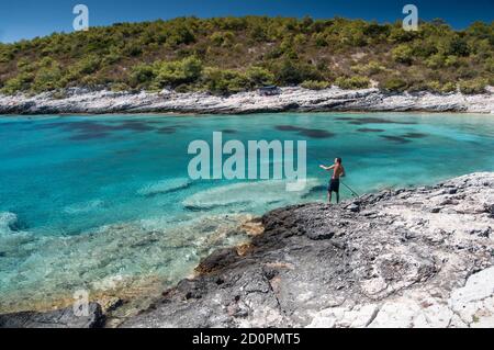 The Fisherman, A man catches fish on the island of Vis, in Croatia, in the summer, on the beach Srebrna Stock Photo