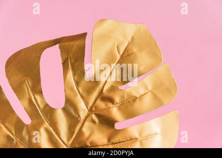 Stylish background with gold leaf of  monstera on pink color Stock Photo