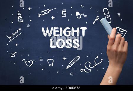 Hand drawing WEIGHT LOSS inscription with white chalk on blackboard, medical concept Stock Photo