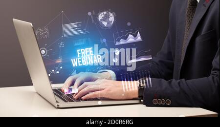Businessman working on laptop with FREE WEBINAR inscription, new business concept Stock Photo
