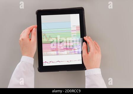Business woman working with trading graphs on tablet pc. Stock Photo