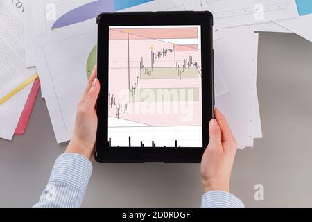 Woman using financial application on digital tablet. Stock Photo