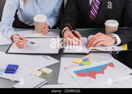 Coworkers analyzing financial reports in office. Stock Photo