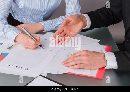 Woman client putting signature on legal document. Stock Photo