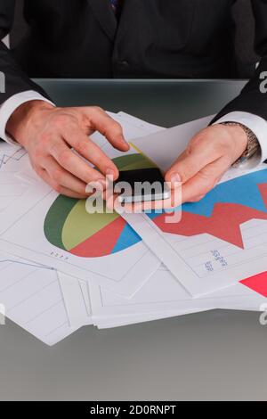 Financial analyst holding smartphone in hands closeup. Stock Photo