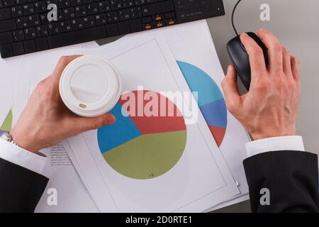 Businessman analyzing investment charts using computer at office. Stock Photo