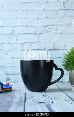 Black mug mockup with with keyboard, notebooks on table  Stock Photo