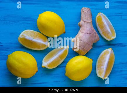 Ripe lemons and root of ginger on the blue background Stock Photo