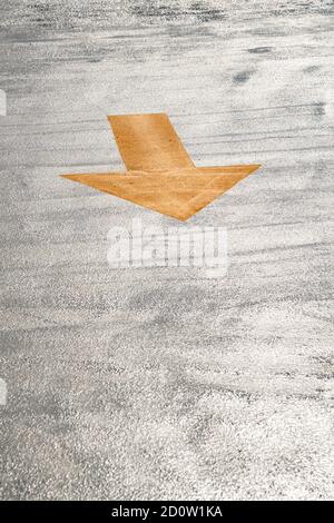 Freshly painted yellow arrow on floor of parking garage, Boston, USA Stock Photo
