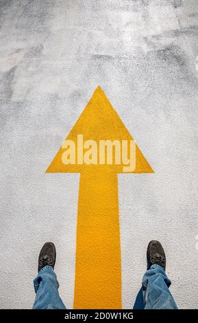 Freshly painted yellow arrow on floor of parking garage, Boston, USA Stock Photo