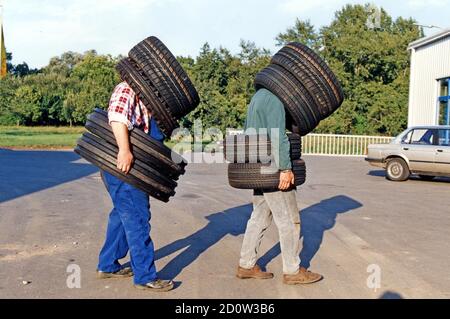 Two men wearing car tires, 2015, Germany, Europe Stock Photo