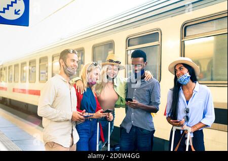 Group of happy smiling young people using mobile phones in train station - Concept of addiction to new technology trends - New normal millennial lifes Stock Photo