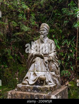 Chinese scholar statue in the jungle Stock Photo