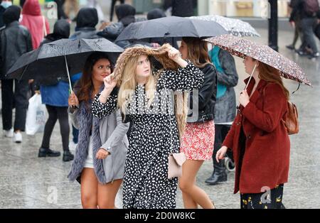 People with umbrellas in Nottingham city centre, as heavy rain is lashing parts of the UK, with the Met Office issuing warnings not seen since March, as winds of up to 65mph are expected along the coast on Saturday along with heavy rain as Storm Alex hits the UK. Stock Photo