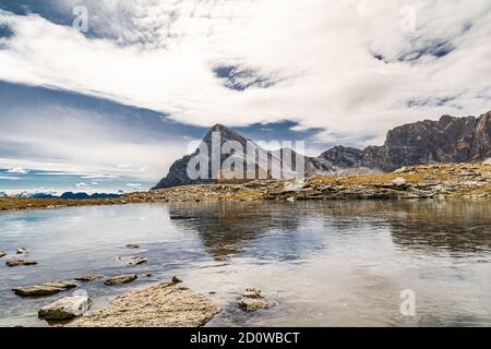 Verkeerd Aangepaste residu At 2700 meters above sea level, the Camoscere lake, covered by a thin layer  of ice, is the natural mirror of the Chersogno, Marchisa, Pelvo d'Elva and  Stock Photo - Alamy