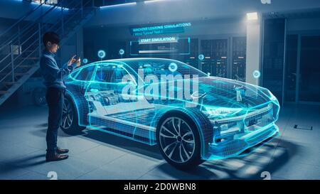 Automotive Engineer Uses Digital Tablet with Augmented Reality for Car Design Analysis and Improvement. 3D Graphics Visualization Shows Fully Stock Photo