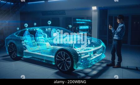 Automotive Engineer Using Digital Tablet Computer with Augmented Reality 3D Software for 3D Car Model Design Analysis and Improvement. Futuristic Stock Photo