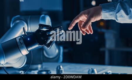 Futuristic Robot Arm Touches Human Hand in Humanity and Artificial Intelligence Unifying Gesture. Conscious Technology Meets Humanity. Concept Stock Photo