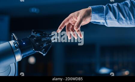 Futuristic Robot Arm Touches Human Hand in Humanity and Artificial Intelligence Unifying Gesture. Conscious Technology Meets Humanity. Concept Stock Photo