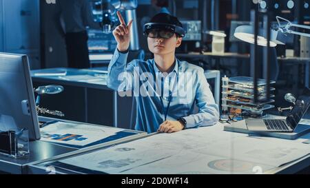 Professional Japanese Development Engineer is Working in a AR Headset, Making Gestures of Touching Virtual Graphics Pieces in the High Tech Research Stock Photo