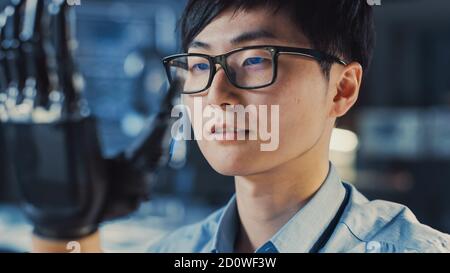 Close Up of a Futuristic Prosthetic Robot Arm Being Tested by a Professional Japanese Development Engineer in a High Tech Research Laboratory with Stock Photo