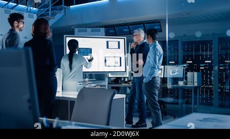 Engineers Meeting in Technology Research Laboratory: Male Engineer Leads Presentation Using Digital Whiteboard, Shows Machine Blueprint, Data Stock Photo