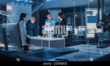 Engineers Meeting in Virtual Reality Content Design Studio: Engineers, Scientists and Game Application Developers Gathered Around Illuminated Gesture Stock Photo