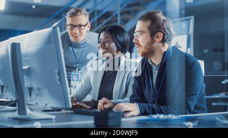 Two Electronics Development Engineers Working on Computers, Talk with Project Manager. Team of Professionals Use CAD Software for the Modern Stock Photo