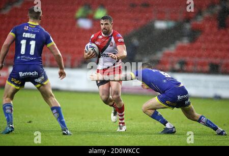 Salford Red Devils' Tyrone McCarthy (centre) tackled by Salford Red Devils' Joey Lussick (right) during the Coral Challenge Cup, Semi Final at The Totally Wicked Stadium, St Helens. Stock Photo