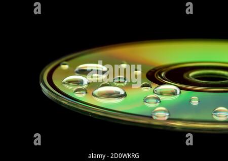 CD with water droplets on it - closeup with selective focus, futuristic colorful background and texture idea Stock Photo