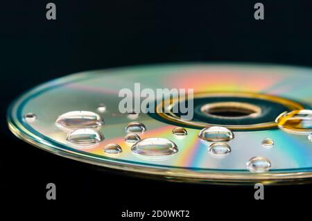 CD with water droplets on it - closeup with selective focus, futuristic colorful background and texture idea Stock Photo