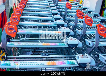 Berlin, Germany - October 3, 2020: View to a row of shopping carts in front of a shop. There is a magnifying glass on the car so that the visually imp Stock Photo