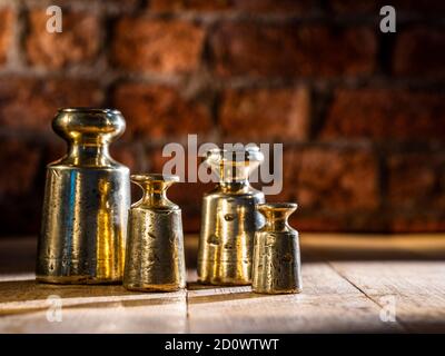 https://l450v.alamy.com/450v/2d0wtwt/vintage-1800s-brass-and-lead-weights-set-of-4-pitted-and-weathered-on-timber-flooring-with-brick-background-2d0wtwt.jpg