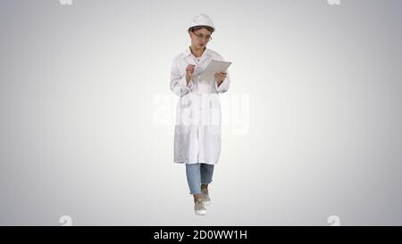 Woman engineer working on tablet on gradient background. Stock Photo
