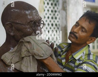 A worker is washing and cleaning the statue of Mahatma Gandhi on the eve of his birth anniversary in Agartala. Tripura, India. Mahatma Gandhi was an Indian lawyer, anti-colonial nationalist, and political ethicist, who employed nonviolent resistance to lead the successful campaign for India's independence from British rule, and in turn inspired movements for civil rights and freedom across the world. Stock Photo