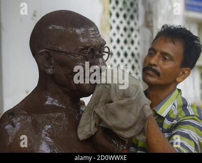 A worker is washing and cleaning the statue of Mahatma Gandhi on the eve of his birth anniversary in Agartala. Tripura, India. Mahatma Gandhi was an Indian lawyer, anti-colonial nationalist, and political ethicist, who employed nonviolent resistance to lead the successful campaign for India's independence from British rule, and in turn inspired movements for civil rights and freedom across the world. Stock Photo