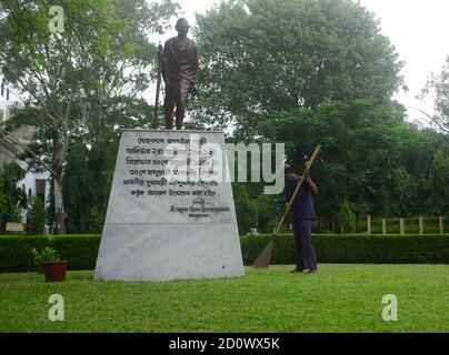 A worker is sweeping near the statue of Mahatma Gandhi on the eve of his birth anniversary in Agartala. Tripura, India. Mahatma Gandhi was an Indian lawyer, anti-colonial nationalist, and political ethicist, who employed nonviolent resistance to lead the successful campaign for India's independence from British rule, and in turn inspired movements for civil rights and freedom across the world. Stock Photo
