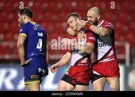 Salford Red Devils' Joey Lussick (centre) celebrates scoring the winning try with team-mate Gil Dudson during the Coral Challenge Cup, Semi Final at The Totally Wicked Stadium, St Helens. Stock Photo