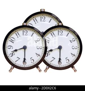 Three identical alarm clocks with white dial and black numbers on an isolated background Stock Photo
