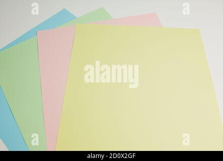 pastel colored papers lying on white background with copy space for any text Stock Photo