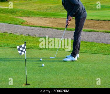 Man Playing Golf.Man Playing Golf on Beautiful Sunny Green Golf Course. Hitting Golf Ball down Stock Photo