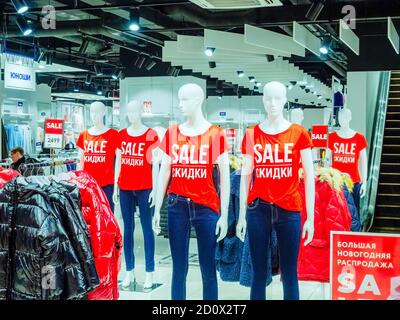 Sochi, Russia - 14 December 2019. White mannequins in red T-shirts with SALE inscription stand in a row inside the store Stock Photo