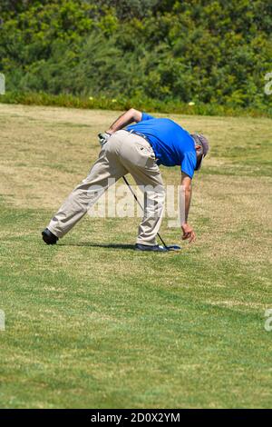 Man Playing Golf.Man Playing Golf on Beautiful Sunny Green Golf Course. Hitting Golf Ball down Stock Photo