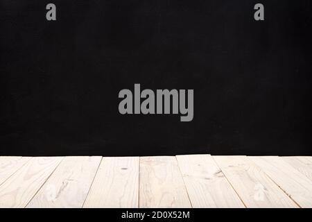 Empty white wooden deck table over black wall background. Mock up template. Copy space Stock Photo