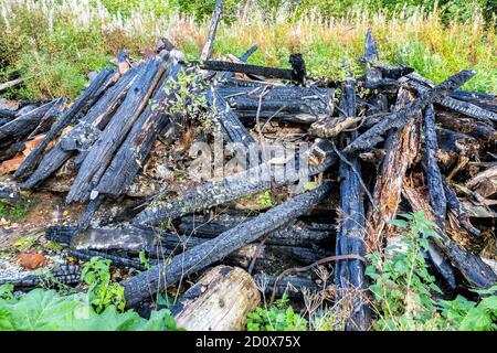 Burned wooden house in village in summertime Stock Photo